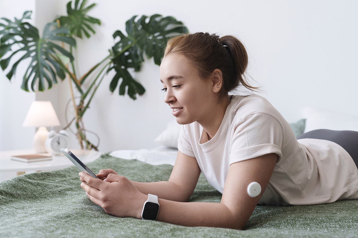 Girl on laying on her bed, typing on her phone